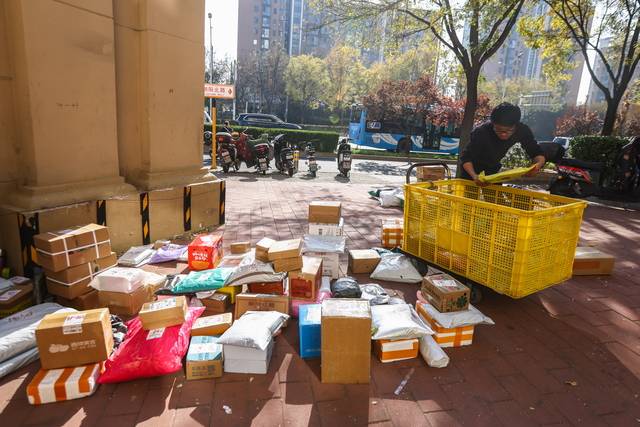 중국의 연중 최대 쇼핑 시즌 광군제를 맞잏나 11일 베이징의 한 아파트단지 앞에서 한 택배 기사가 배송 상품을 정리하고 있다. EPA 연합뉴스