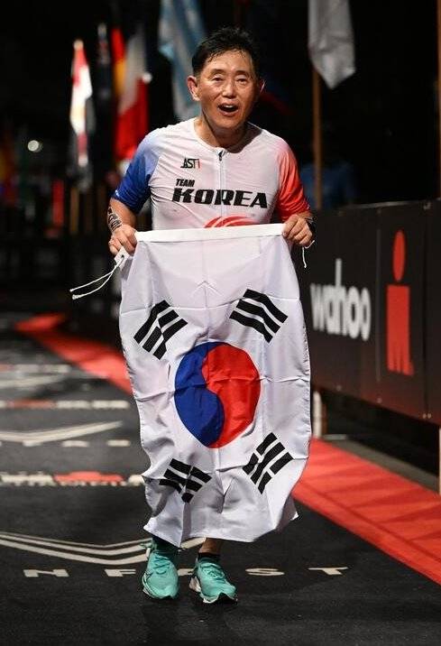 강준환 원장이 2022년 10월 8일 미국 하와이 코나에서 열린 아이언맨 세계선수권대회를 완주한 뒤 태극기를 들고 질주하고 있다. 강준환 원장 제공