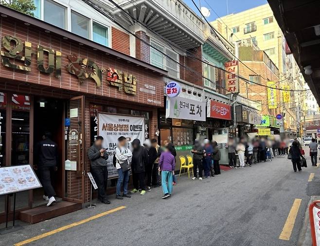 완미족발 서울상봉점 앞, 고객들로 긴 줄이 이어져 있는 모습
