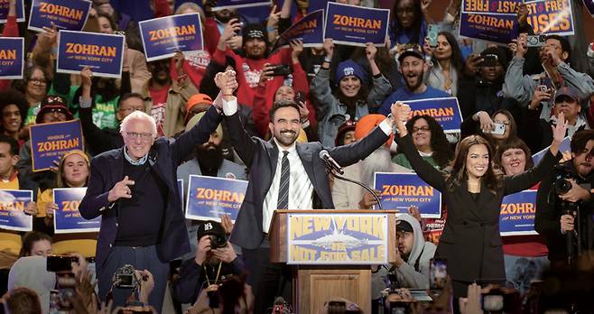 10월26일 뉴욕시 포리스트힐 스타디움에서 열린 '뉴욕은 팔리지 않는다' 선거 캠페인 집회의 조란 맘다니 시장(당시 시장 후보). 왼쪽은 버니 샌더스 연방 상원의원, 오른쪽은 알렉산드리아 오카시오 코르테스 연방 하원의원 ⓒUPI 연합