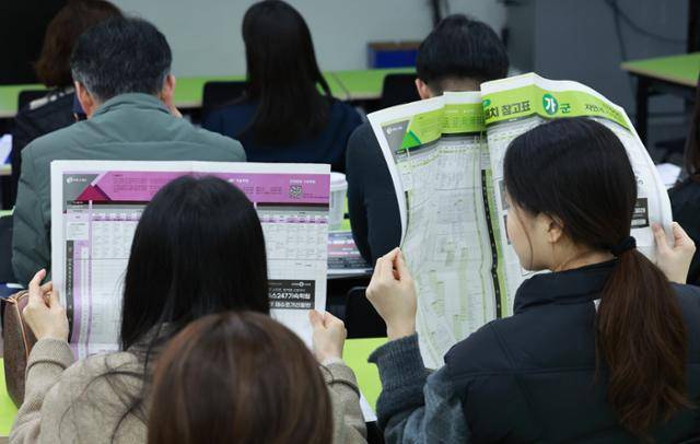 이투스에듀 주최로 지난 15일 서울 강남하이퍼학원 본원에서 열린 '2026 수능 가채점 설명회'에 참석한 수험생과 학부모들이 대학 배치 참고표를 살피고 있다. 연합뉴스