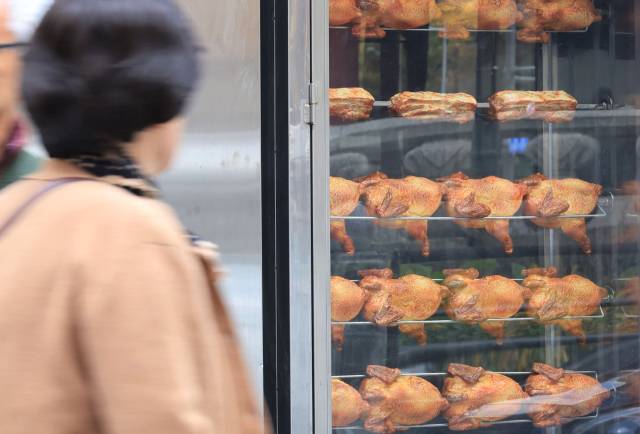 한 시민이 치킨집 앞을 지나고 있다. 연합뉴스