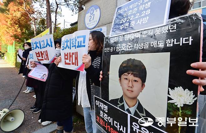17일 오후 수원시 영통구 효동초등학교 정문 앞에서 진행된 유은혜 전 교육부장관 방문 규탄 집회에서 관계자들이 백신 피해 학생 피켓을 들고 구호를 외치고 있다. 임채운기자