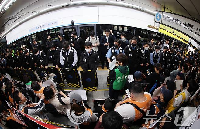 21일 서울 지하철 4호선 혜화역 동대문 방면 승강장에서 열린 제62차 '출근길 지하철 탑니다' 시위에서 전국장애인차별철폐연대(전장연) 회원들이 경찰·서울교통공사 직원 등과 대치하고 있다.2025.4.21/뉴스1 ⓒ News1 이동해 기자