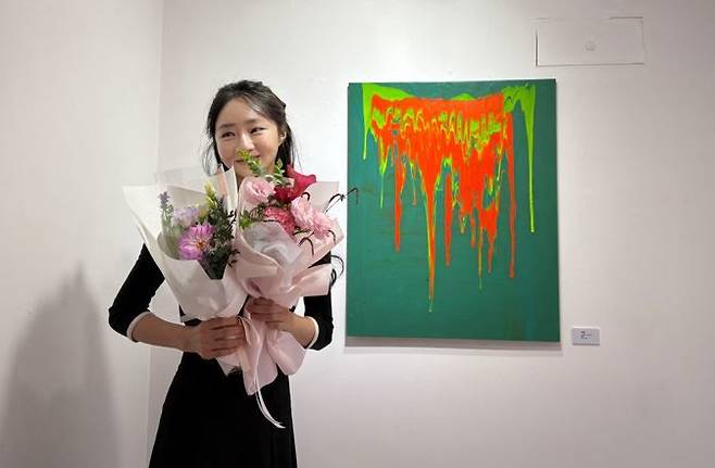 지난달 말 서울 강남구 자신의 그림 전시회 ‘다결랩소디’에서 꽃다발을 안고 있는 강지현 대표.