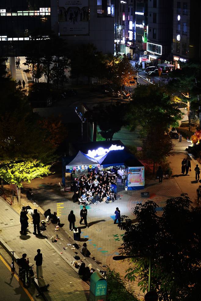 8일 저녁 서울 마포구 홍대입구역 6번 출구 인근에 설치된 ‘서울시립십대여성일시지원센터 나무’ 상담 천막에서 활동가와 청소년들이 “경의선! 파이팅!”을 외치며 마지막 거리 상담을 기념하는 사진을 찍고 있다. 가족의 속박을 피해 길에서 지내는 청소년들의 얼굴을 알아보고 가족들이 찾아오는 경우가 있어 청소년들의 얼굴은 보이지 않게 처리했다. 김혜윤 기자 unique@hani.co.kr