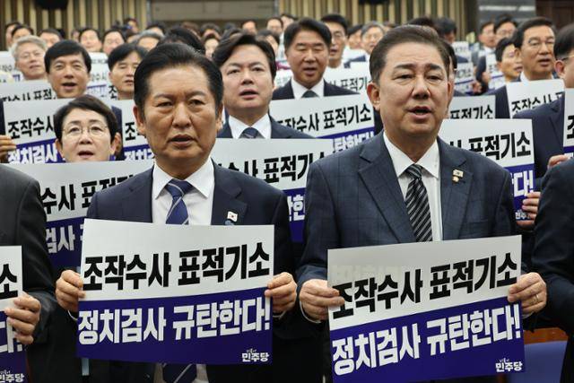 정청래 더불어민주당 대표와 김병기 원내대표가 13일 서울 여의도 국회에서 열린 의원총회에서 "정치검사 규탄한다!"라고 적힌 팻말을 들고 구호를 외치고 있다. 연합뉴스
