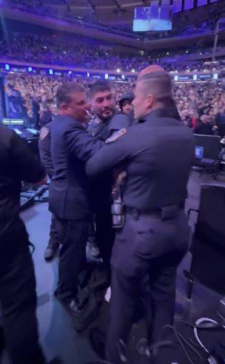 딜런 데니스가 UFC 322에서 난투극을 벌인 뒤 보안요원에게 잡혀 있는 모습. 사진=MMA 정키 X