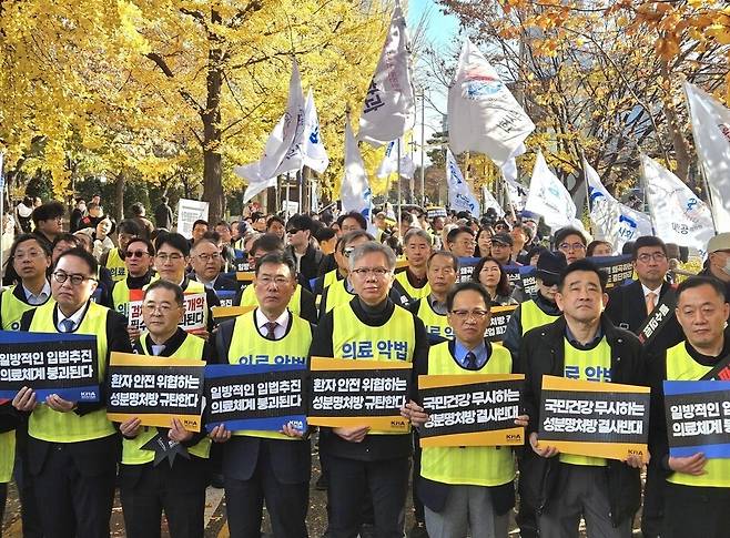 김택우 대한의사협회 회장(앞줄 가운데)을 비롯한 의사들이 16일 국회 앞에서 열린 '국민건강수호 및 의료악법 저지를 위한 전국 의사 대표자 궐기대회'에서 피켓을 들고 있다. ⓒ대한의사협회