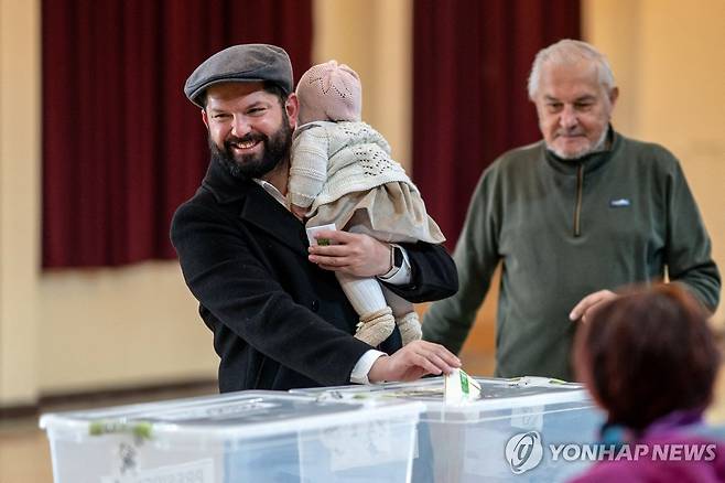 16일(현지시간) 딸 안고 대선 투표장 찾은 가브리엘 보리치 칠레 대통령 [칠레 대통령실 제공. 푼타아레나스=AFP 연합뉴스. 재판매 및 DB 금지]