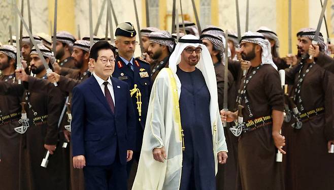 ▲ 이재명 대통령이 18일(현지시간) 아랍에미리트(UAE) 아부다비 대통령궁에서 열린 국빈방문 공식 환영식에서 무함마드 빈 자이드 알 나흐얀 UAE 대통령과 사열대로 이동하고 있다. /연합뉴스