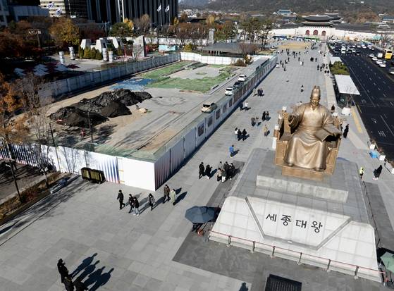 시민들이 18일 서울시가 6·25 전쟁 참전국을 기리기 위해 광화문광장에 조성할 계획인 '감사의 정원'의 공사현장 주변을 오가고 있다. 연합뉴스