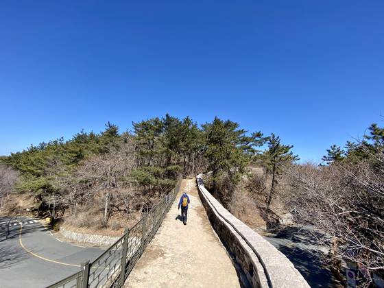 산성고개는 부산의 진산 금정산의 고개다. 금성동에서 장전동 사이의 고갯마루 위 산성으로 한 등산객이 지나가고 있다. 이 고개 너머의 산성마을은 재산권 행사를 위해 금정산국립공원에서 빠졌다. 김홍준 기자