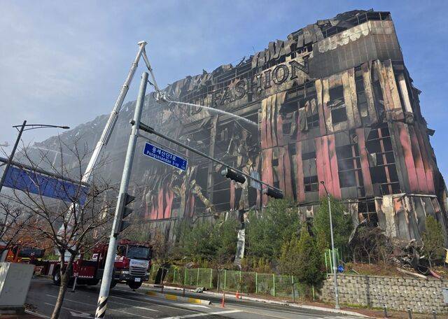 충남 천안시 이랜드패션 물류센터 화재 발생 사흘째인 17일 센터 외벽이 검게 그을려 있다. 주불을 잡은 소방 당국은 중장비를 동원해 건물을 해체하며 분당 최대 7만5000ℓ의 물을 투입해 잔불을 정리하고 있다.