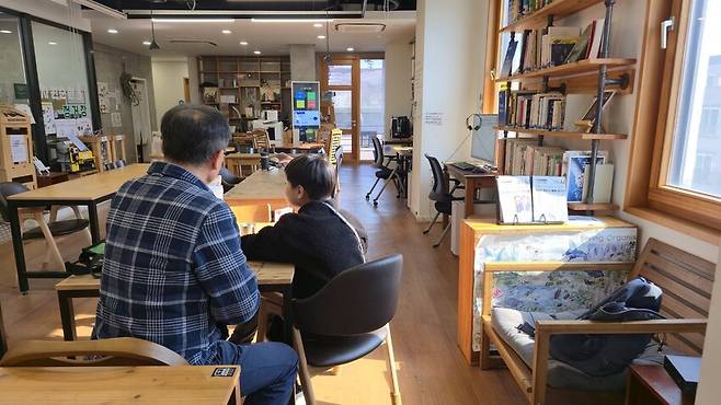 주아무개(12)군이 2025년 11월4일 경기도 용인의 한 도서관에서 한 목사와 책을 읽고 있다. 학교 통합교실에서의 손쉬운 분리, 교육청의 무관심 속에 교육받을 권리를 침해당한 주군은 현재 지역사회 어른들의 교육봉사에 힘입어 공부하고 있다. 손고운 기자