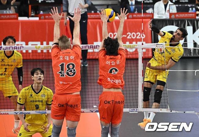 [OSEN=부산, 이석우 기자] 18일 부산 강서실내체육관에서 진에어 2025-2026 V리그 남자부 OK저축은행과 KB손해보험의 경기가 열렸다. 부산 시대를 연 OK저축은행의 신영철 감독이 한국 최초 300승을 기록할지 기대된다.KB손해보험 모하메드 야쿱이 OK저축은행 오데이, 이민규의 블로킹을 뚫고 스파이크를 날리고 있다. 2025.11.18 / foto0307@osen.co.kr