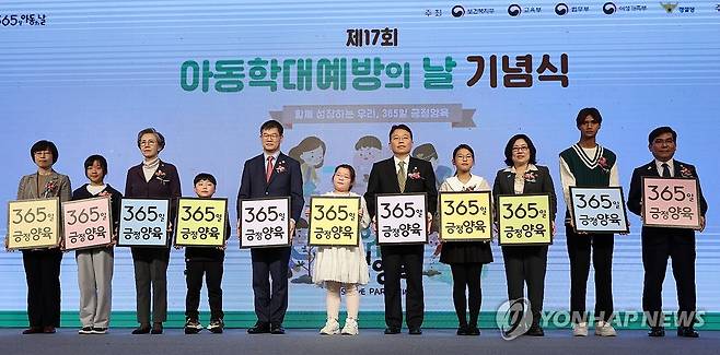 '365일, 긍정양육' 보건복지부가 2023년 11월 17일 오후 서울 마포구 가든호텔에서 연 '제17회 아동학대예방의 날 기념식'에서 참가자들이 '365일 긍정 양육'이라고 적힌 손팻말을 들고 기념 촬영을 하고 있다.[연합뉴스 자료사진]