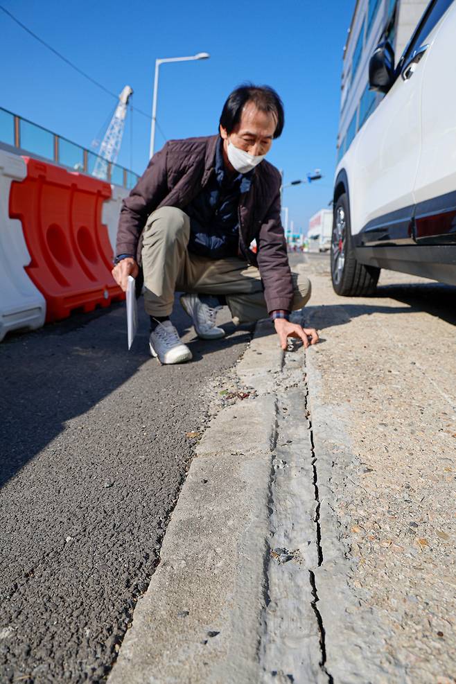 송정 지하차도 공사현장 인근에서 15년째 낚시용품점을 운영하고 있는 김기현 씨가 공사장 진동으로 지반에 생긴 틈새를 짚고 있다. 틈새에는 땜질한 듯 임시로 덧댄 시멘트가 굳어 있었지만, 이조차 깨진 곳이 많았다. 최지원 기자