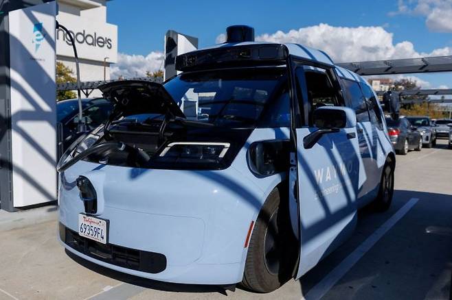 중국 자동차 제조업체 지리와 함께 개발한 웨이모 지커 로보택시 모델이 19일(현지시간) 미국 캘리포니아주 샌디에이고에서 무인 서비스 확장을 시작하기 전 테스트 중 공공 충전소에서 충전하고 있다. 연합뉴스