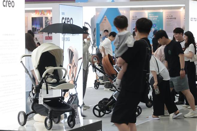 Parents of newborns are seen at a baby fair held at Coex in Gangnam District, southern Seoul on Aug. 17. [YONHAP]