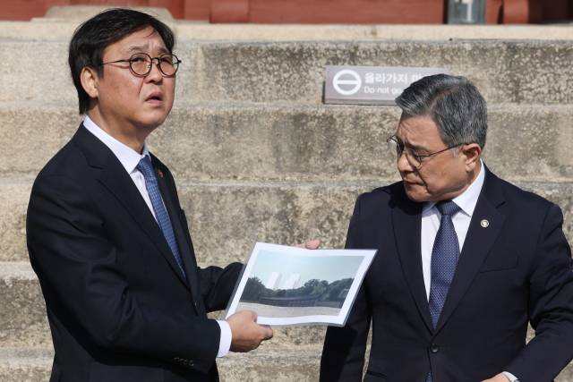 최휘영 문화체육관광부 장관과 허민 국가유산청장이 7일 종묘를 방문해서 시뮬레이션 이미지 자료를 들고 남쪽으로 보이는 경관을 살펴보고 있다. 연합뉴스