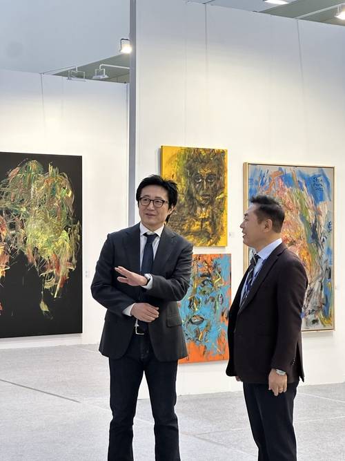 배우에서 화가로 변신한 박신양 작가가 ‘인천아트쇼 2025’에서 진행 중인 ‘박신양 특별전’에서 정광훈 인천아트쇼조직위원장에게 자신의 작품에 대해 설명하고 있다. 2025.11.21 /인천아트쇼조직위원회 제공