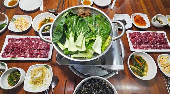 해남 성내식당의 생고기와 샤부샤부 상차림. 샤부샤부 냄비 왼쪽의 고기가 샤부샤부에 들어가는 살치살 생고기고, 오른쪽이 날로 먹는 우둔살 생고기다.
