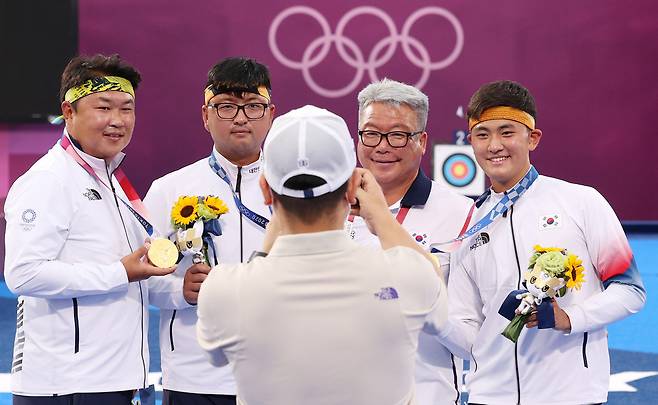 2021년 7월 26일 일본 도쿄 유메노시마 공원 양궁장에서 열린 도쿄올림픽 남자양궁 단체전에서 금메달을 목에 건 오진혁(왼쪽부터), 김우진, 김제덕(오른쪽)이 박채순 총감독과 기념촬영을 하고 있다. 뉴시스