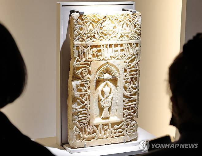 메카 방향 표시하는 미흐랍 석판 (서울=연합뉴스) 이재희 기자 = '이슬람 미술, 찬란한 빛의 여정' 전시가 열린 21일 서울 국립중앙박물관 상설전시관에서 취재진 및 관계자들이 모스크에서 메카 방향을 표시하는 벽감인 미흐랍 석판을 살펴보고 있다. 이 전시는 2026년 10월 11일까지 열린다. 2025.11.21 scape@yna.co.kr