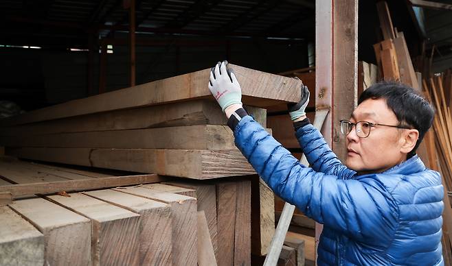 신 본부장이 바둑판 모양으로 원목을 재단하기 위해 목재를 들어내고 있다.