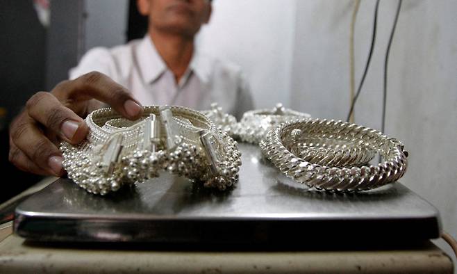 인도의 한 거래소에서 은제품의 무게를 재고 있다. 로이터연합뉴스