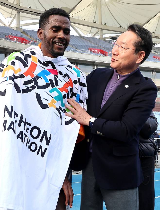 ▲ 23일 인천 미추홀구 문학경기장에서 열린 '2025 인천마라톤'에 참석한 유정복 인천시장이 엘리트 국제부 남자부문 우승 선수에게 타월을 걸어주고 있다. /이재민 기자 leejm@incheonilbo.com