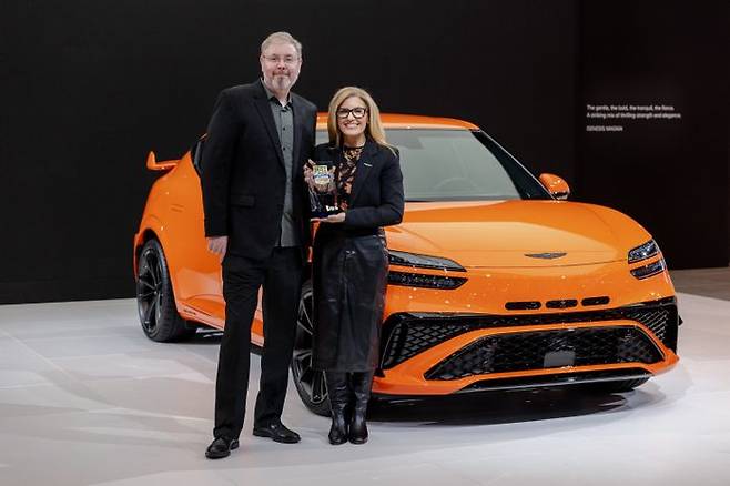 (왼쪽부터) 알렉스 크완텐(Alex Kwanten) US 뉴스 앤드 월드 리포트 편집장과 제네시스 북미법인 최고마케팅책임자(CMO) 에이미 마렌틱(Amy Marentic)이 수상패를 들고 GV60 마그마 차량 앞에서 사진 촬영을 하고 있다. ⓒ제네시스