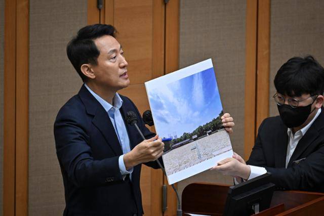 오세훈 서울시장이 18일 서울 중구 서울시의회에서 열린 제333회 정례회 시정질문에 참석해 종묘 앞 세운4구역 재개발 관련 자료 사진을 들어 보이며 의원들 질문에 답하고 있다. 정다빈 기자