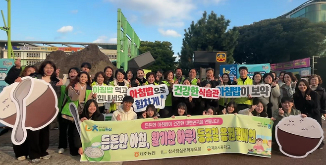 든든한 아침 캠페인에 참여한 제주서중 학생·학부모·교직원·제주농협 관계자들이 등굣길 응원을 마친 뒤 함께 기념사진을 촬영하고 있다. (제주농협 제공)