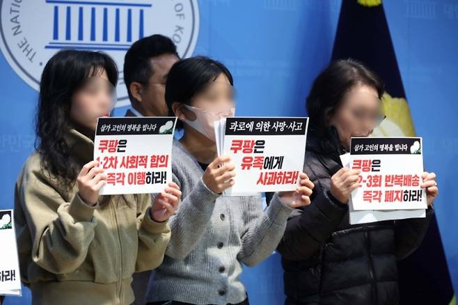 지난 19일 오전 서울 여의도 국회 소통관에서 열린 '제주 쿠팡 새벽배송 희생자 고 오승용 유족, 원내 제정당 공동기자회견'에서 유가족들이 손피켓을 들고 있다.