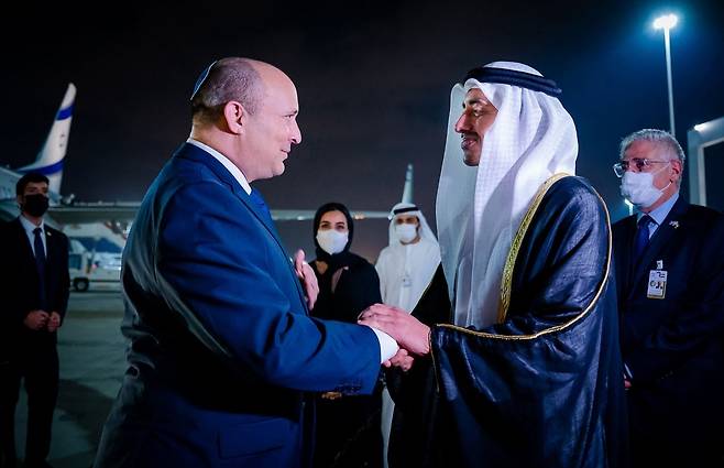 지난 2021년 12월  12일(현지시간) 나프탈리 베네트 당시 이스라엘 총리(왼쪽)가 아부다비 국제공항에 도착해 압둘라 빈 자이드 알 나흐얀 아랍에메리트 외교부 장관으로부터 환영 인사를 받았다. UAE가 아브라함 협정에 가입, 이스라엘과 정식으로 수교하면서 이날 최초로 이스라엘 총리가 UAE를 방문하는 역사적  장면이 연출됐다.[AFP]