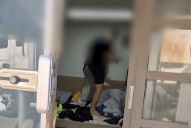 강원 양양군 7급 운전직 공무원이 환경미화원들을 폭행하는 등 지속적으로 괴롭혀 왔다는 의혹이 제기됐다. 사진은 해당 공무원이 이른바 ‘계엄령 놀이’라며 쉼터에서 이불 안에 있는 환경미화원을 발로 밟는 모습. MBC 보도 화면 캡처