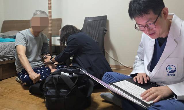 기승국(오른쪽) 홈닥터예방의학과의원 원장 이 거동이 불편해져 병원 방문이 어려운 어르신의 집에서 약을 처방하는 사이 강소윤(오른쪽) 간호사가 혈압을 측정하고 있다. 안경진 기자