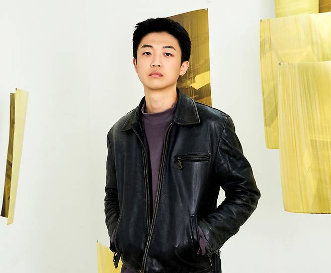 ▲ 강지웅 작가가 인천아트플랫폼 작업실에 전시된 자신의 작품 사이에 서 있다. 그는 사진을 물속이나 갯벌에 담가 변형되는 과정을 통해 시간의 흔적을 담는 작업을 이어오고 있다. /사진제공=인천아트플랫폼