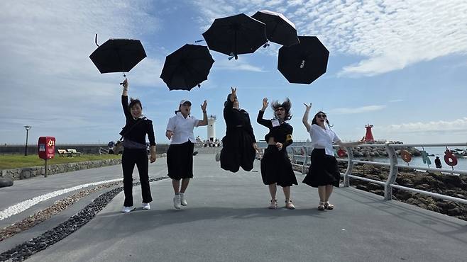 ▲ 신라문화원이 진행한 '2025 추억의 경주 수학여행'에 참가한 이현승 노래교실 회원들이 감포항에서 기념촬영을 하고 있다. 신라문화원