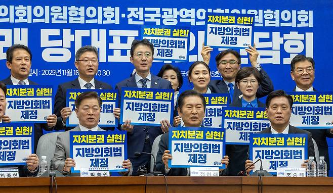 더불어민주당 정청래 대표가 18일 국회에서 열린 전국기초·광역의회의원협의회 간담회에서 전국 지방의회 의원 협의회 대표들과 지방 선거 필승을 다짐하는 손팻말을 들고 구호를 외치고 있다. /김지호 기자