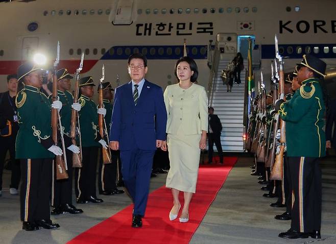 주요 20개국(G20) 정상회의에 참석하는 이재명 대통령이 김혜경 여사와 함께 21일(현지시간) 남아프리카공화국 요하네스버그 OR탐보국제공항에 도착한 뒤 공군 1호기에서 내려 이동하고 있다. ⓒ연합뉴스
