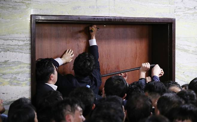 더불어민주당 당직자와 국회 관계자들이 2019년 4월26일 새벽 여야4당의 수사권조정법안을 제출하기 위해 자유한국당 당직자들이 점거한 국회 의안과 진입을 시도하고 있다. 이 과정에서 도구가 사용됐다. 연합뉴스