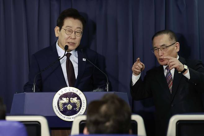President Lee Jae Myung, left, and National Security Advisor Wi Sung-lac speak during a press conference with reporters aboard the Korean Air Force One en route to Ankara, Turkey, on Nov. 23. [JOINT PRESS CORPS]
