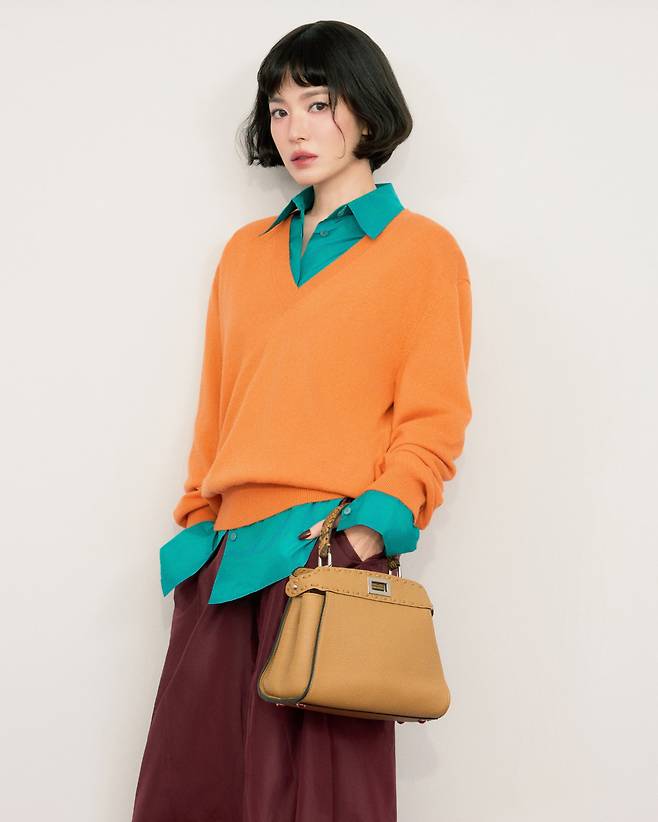 송혜교와 함께 한 220개의 핸드 스티칭으로 완성된 카푸치노 컬러 셀러리아 ‘미니 피카부’ 백. 트위스트 락 장식과 실버 셀러리아 로고 플레이트가 특징이며, 탈부착, 조절 가능한 숄더 스트랩이 포함되어 있다. 펜디.