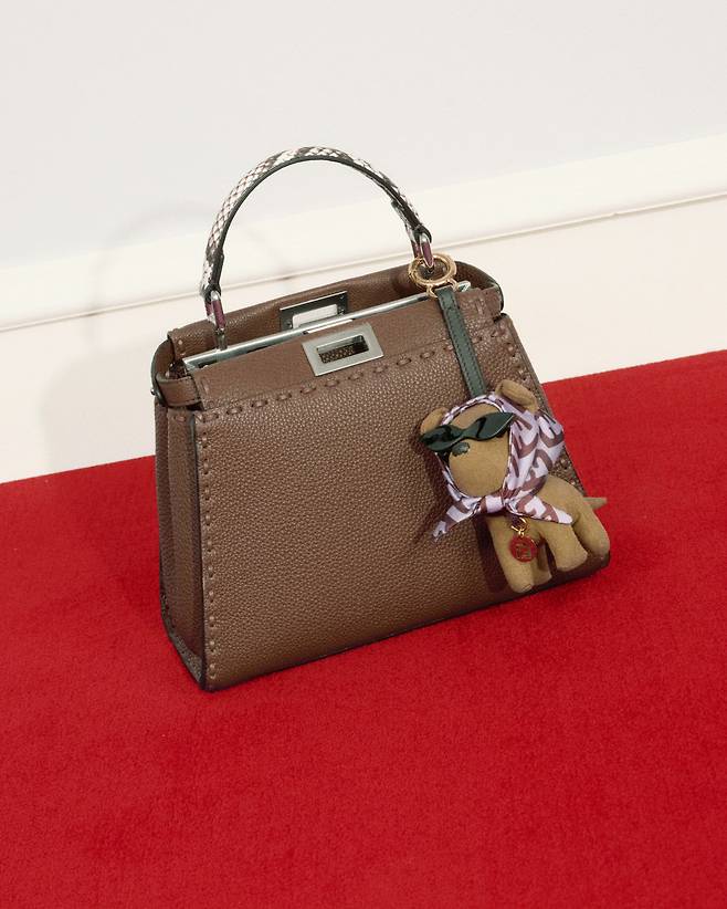 220개의 핸드 스티칭으로 완성된 헤이즐넛 컬러 ‘셀러리아 피카부 미니’ 백과 브라운 FF 마이크로파이버 소재의 ‘지나 펜디 참’. 펜디.