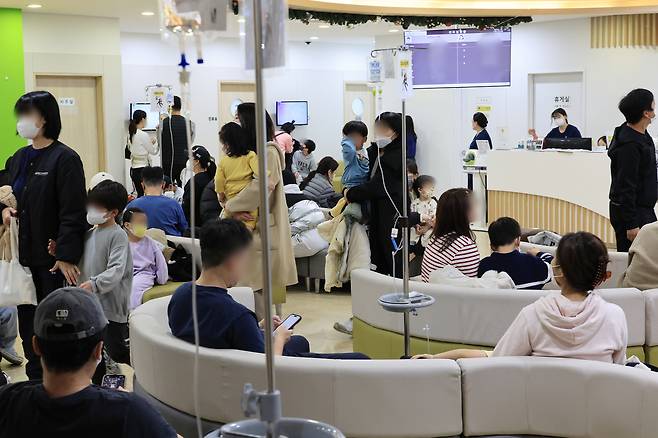 Patients and their guardians crowd a pedriatic clinic in Seongbuk District, northern Seoul, on Nov. 23, amid a surge in flu cases. [YONHAP]