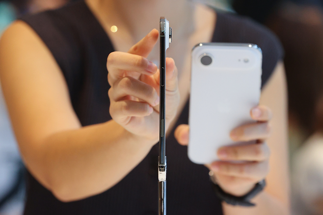 애플의 신제품 아이폰17 시리즈 공식 출시일인 지난 9월 19일 서울 중구 애플 명동점에서 직원이 역대 가장 얇은 모델인 아이폰 에어를 들어보이고 있다. [연합]