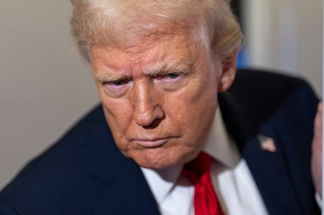 도널드 트럼프 미국 대통령이 25일(현지시간) 플로리다주 팜비치로 향하는 대통령 전용기(에어포스원)에서 기자들과 대화를 나누고 있다. [AP]